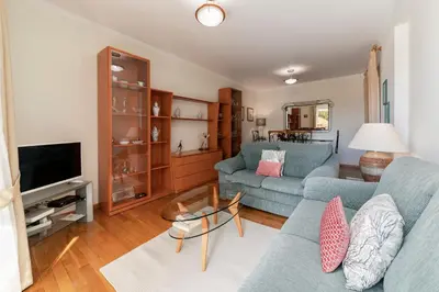 a living room with two blue couches and a television at Ilhéus III by An Island Apart in Funchal