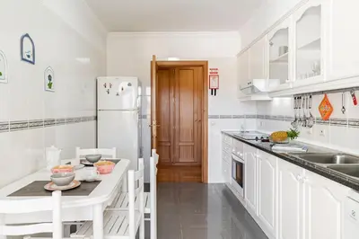 a kitchen with white cabinets and a white refrigerator at Ilhéus III by An Island Apart in Funchal