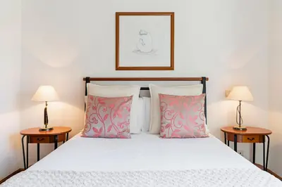 a bedroom with a white bed with two lamps at Ilhéus III by An Island Apart in Funchal