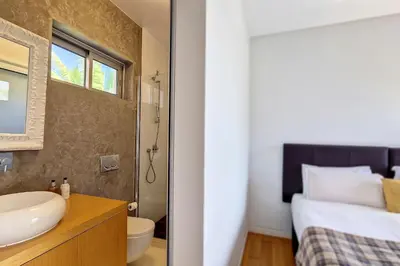 a bathroom with a sink and a toilet and a bed at Villa Ravenala - by LovelyStay in Funchal