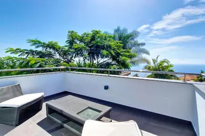 a balcony with a table and chairs and the ocean at Villa Ravenala - by LovelyStay in Funchal
