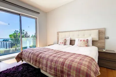 a bedroom with a bed and a large window at Villa Ravenala - by LovelyStay in Funchal