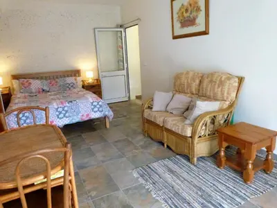 a bedroom with a bed and a couch and a table at Vivenda Linda Vista in Porto da Cruz