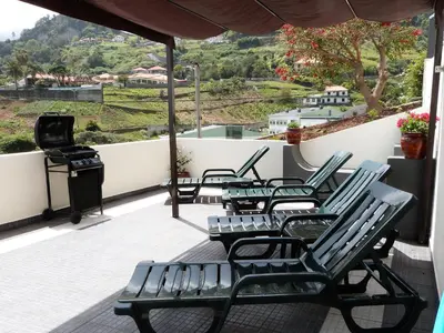 a group of chairs sitting on a balcony with a grill at Vivenda Linda Vista in Porto da Cruz