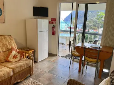 a living room with a table and a refrigerator at Vivenda Linda Vista in Porto da Cruz
