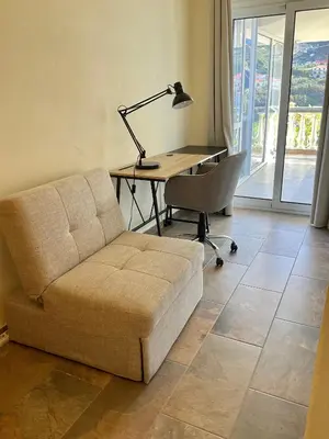 a living room with a couch and a desk with a lamp at Vivenda Linda Vista in Porto da Cruz