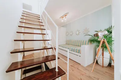 a staircase in a living room with a bench at Paul do Mar Beach House in Paul do Mar