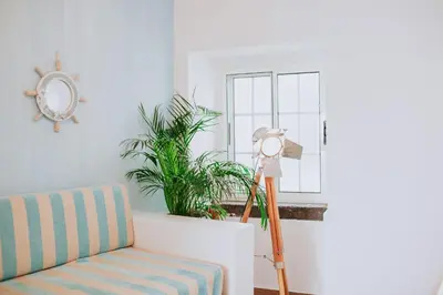 a floor lamp in a living room next to a couch at Paul do Mar Beach House in Paul do Mar