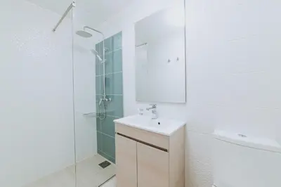 a white bathroom with a sink and a shower at Paul do Mar Beach House in Paul do Mar