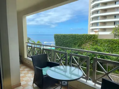 a balcony with a table and chairs and a view of the ocean at Quinta Falesia Apartment in Funchal