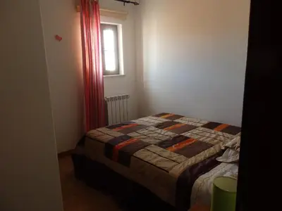 a small bedroom with a bed and a window at Casa Riqueta Silva in Bordeira