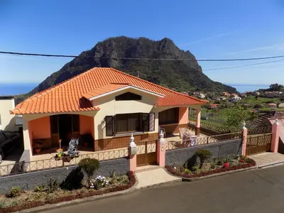 a house with a mountain in the background at Pereira's house - Mountain & Sea in Porto da Cruz