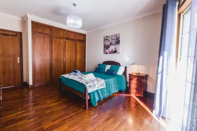 a bedroom with a bed and a wooden floor at Funchal Downtown by ALMA Holiday Rentals in Funchal