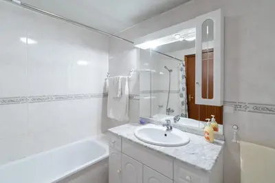 a white bathroom with a sink and a bath tub at Apartamento Alberto in Funchal