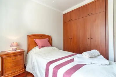a bedroom with a bed and a wooden cabinet at Apartamento Alberto in Funchal