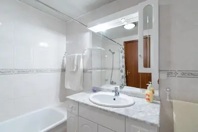 a white bathroom with a sink and a bath tub at Apartamento Alberto in Funchal