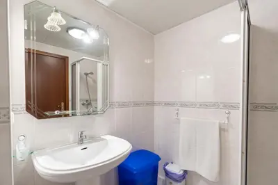 a white bathroom with a sink and a mirror at Apartamento Alberto in Funchal
