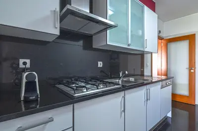 a kitchen with white cabinets and stainless steel appliances at Sunset Apartment by Holiday Rental Madeira in Funchal