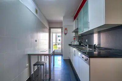 a kitchen with white cabinets and a stove top oven at Sunset Apartment by Holiday Rental Madeira in Funchal