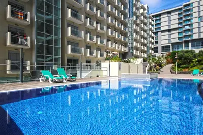 a hotel with a swimming pool in front of two tall buildings at Sunset Apartment by Holiday Rental Madeira in Funchal