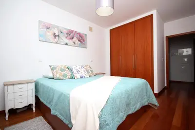 a bedroom with a bed and a wooden cabinet at Sunset Apartment by Holiday Rental Madeira in Funchal