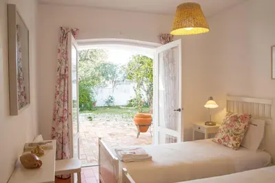 a bedroom with a bed and a door to a patio at FLH Praia da Luz House with Terrace in Luz
