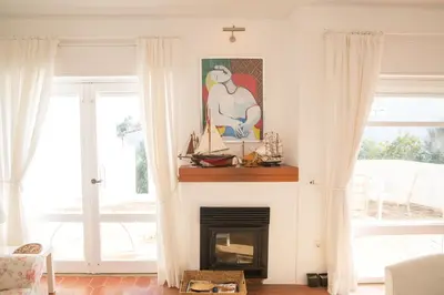 a living room with a fireplace with a picture on the wall at FLH Praia da Luz House with Terrace in Luz
