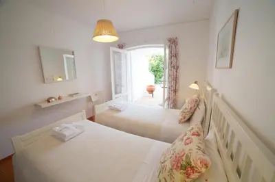 a bedroom with two beds and a window at FLH Praia da Luz House with Terrace in Luz