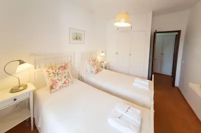 a bedroom with two beds and a lamp on a table at FLH Praia da Luz House with Terrace in Luz