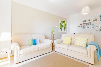 a living room with two white chairs and a couch at Ajuda II by An Island Apart in Funchal