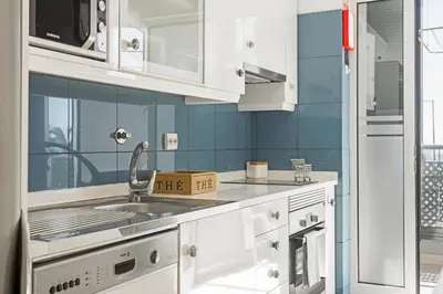 a kitchen with white cabinets and a sink at Ajuda II by An Island Apart in Funchal