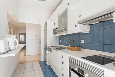 a kitchen with white counters and blue cabinets at Ajuda II by An Island Apart in Funchal