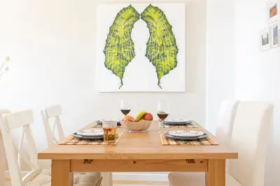 a wooden table with a bowl of fruit and glasses of wine at Ajuda II by An Island Apart in Funchal