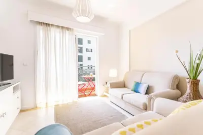 a white living room with a couch and a tv at Ajuda II by An Island Apart in Funchal