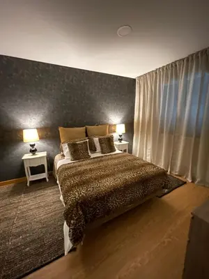 a bedroom with a bed and two lamps on two tables at Queimada Houses in Funchal