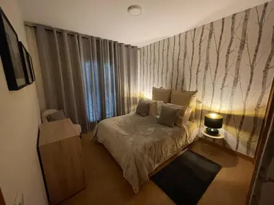 a bedroom with a bed and a large window at Queimada Houses in Funchal