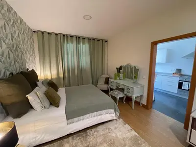 a bedroom with a bed and a desk with a mirror at Queimada Houses in Funchal