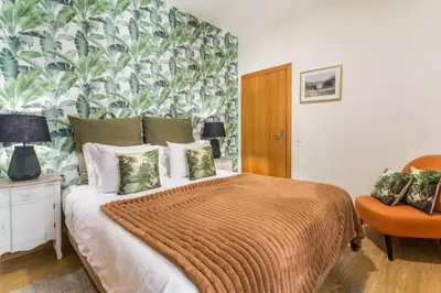 a bedroom with a bed with a tropical wallpaper at Queimada Houses in Funchal