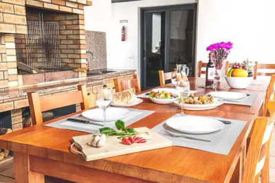 a wooden table with plates of food on it at Barreiros House in Funchal