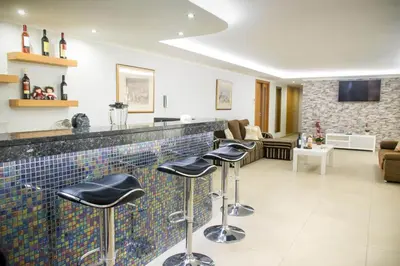 a bar in a living room with stools at Barreiros House in Funchal