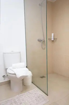 a bathroom with a toilet and a glass shower at Barreiros House in Funchal