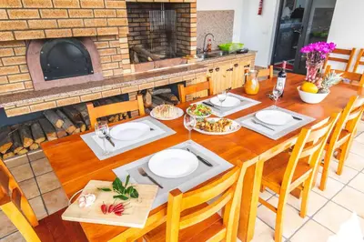 a dining room table with chairs and a fireplace at Barreiros House in Funchal
