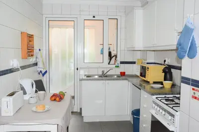 a kitchen with white cabinets and a table with fruit on it at Vista Formosa Funchal in Funchal