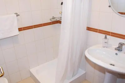 a bathroom with a shower curtain and a sink at Vista Formosa Funchal in Funchal