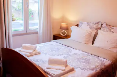 a bedroom with a bed with towels and a window at Vista Formosa Funchal in Funchal