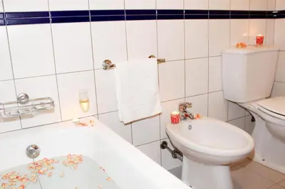 a bathroom with a toilet and a tub and a sink at Vista Formosa Funchal in Funchal