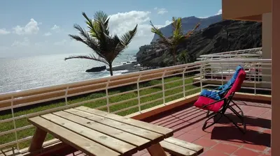 a wooden bench sitting on a balcony overlooking the ocean at Vista Formosa Funchal in Funchal