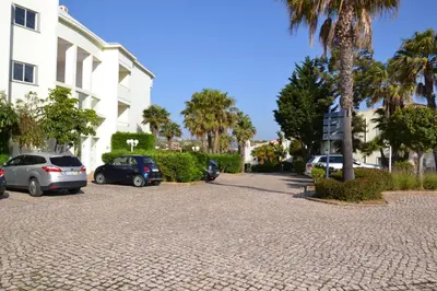 a parking lot with cars parked next to a building at Bel appartement au bord de la mer de Porto de Mos in Lagos