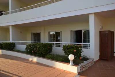 a balcony of a building with bushes and flowers at Bel appartement au bord de la mer de Porto de Mos in Lagos