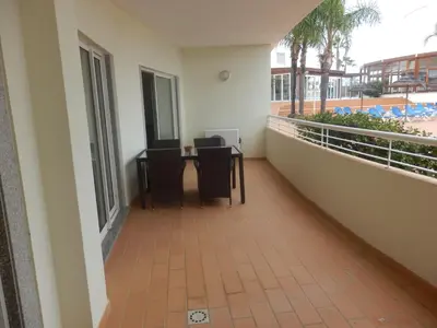 a balcony of a building with a table and chairs at Bel appartement au bord de la mer de Porto de Mos in Lagos